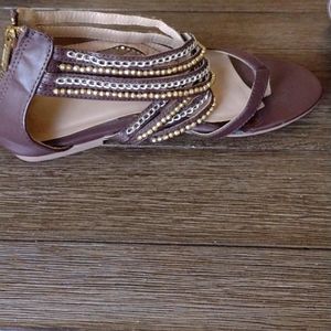 Brown with gold and silver embellishments. Zipper. Has wear in front. See pics